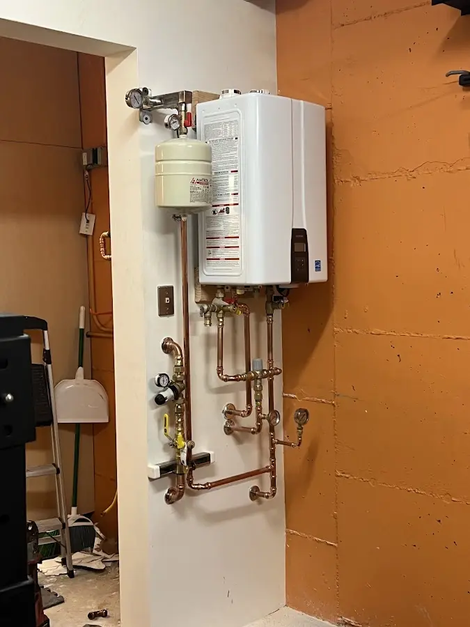 Plumbing technician inspecting water heater connections in Peabody